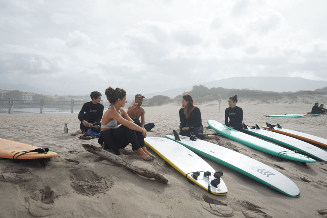 Surflehrer mit Schülern am Strand im Goodtimes Surfcamp