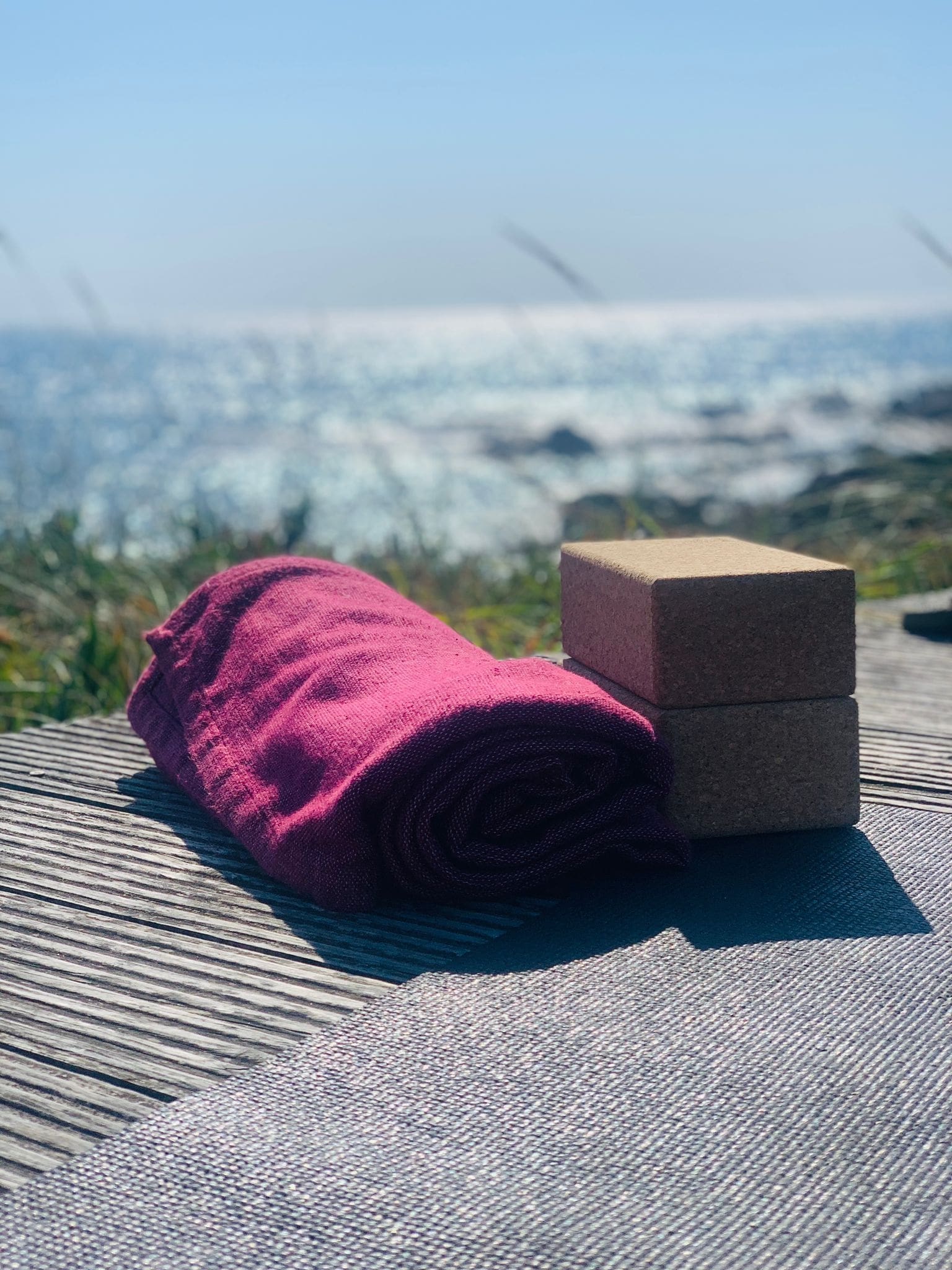 Goodtimes Surfcamp Yoga Retreat Yogamatte, Decke und Yogablöcke auf Plattform am Meer