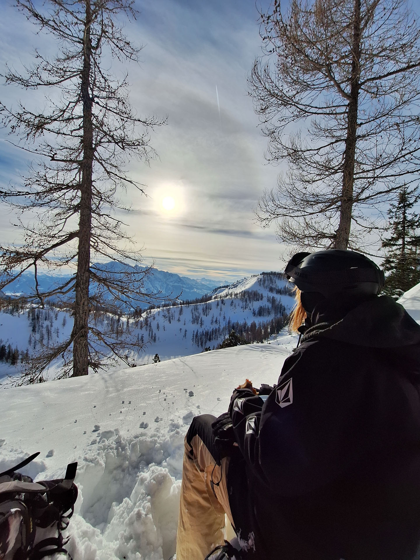 Goodtimes Sportreisen Snowcamp Österreich. Snowboarderin Blickt auf verschneites Gelände
