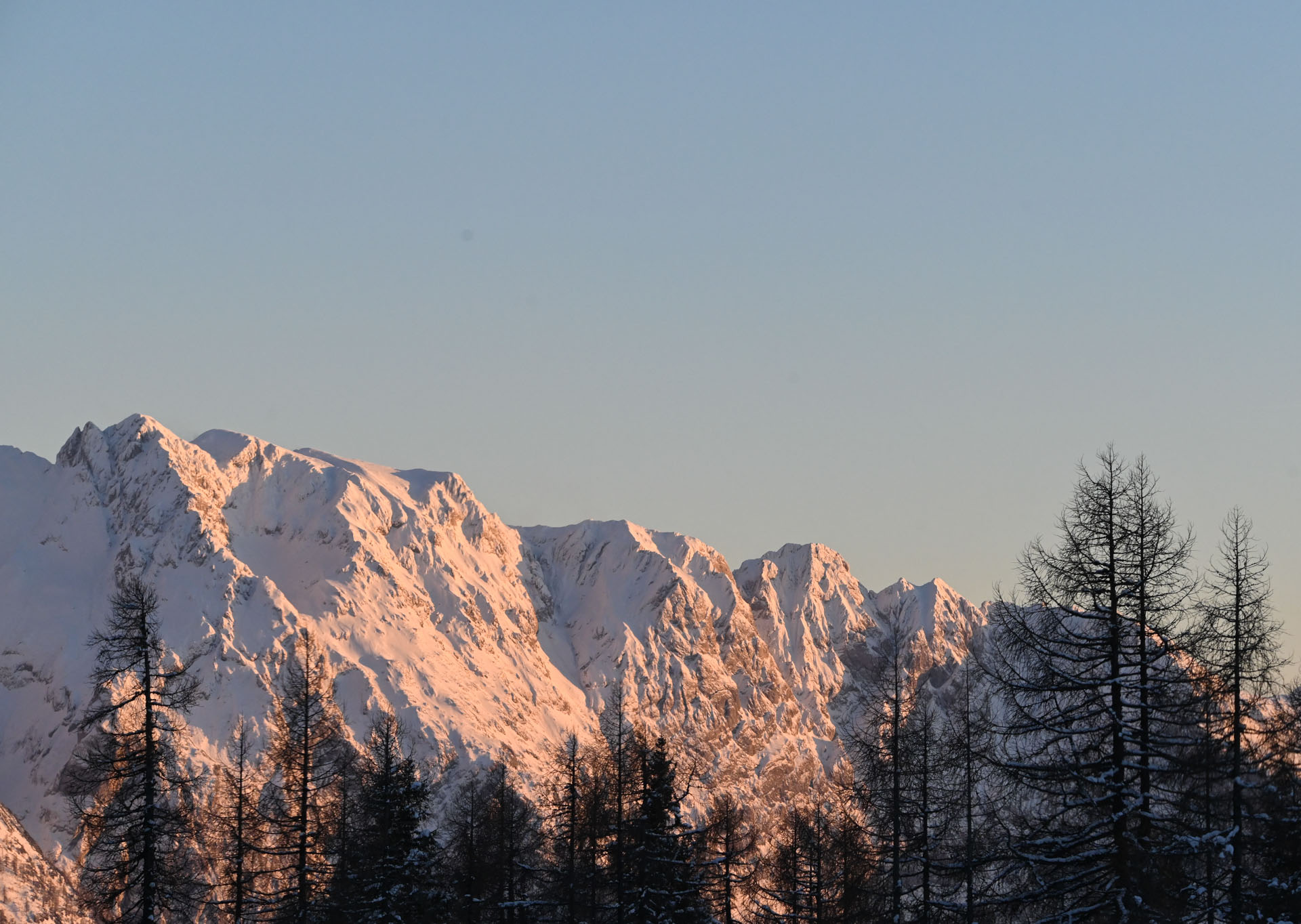 Goodtimes Sportreisen Snowcamp Österreich. Blick auf verschneite Berge in der Abendsonne