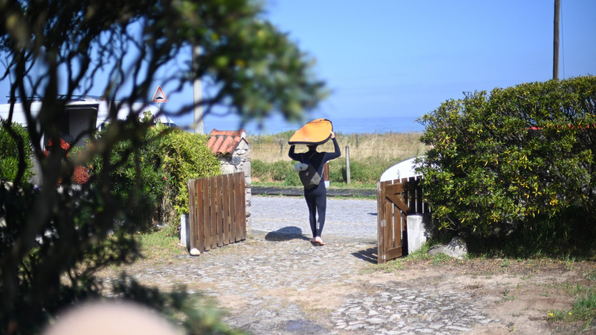 Goodtimes Sportreisen Surfcamp Portugal Surferin mit Board auf dem Weg zum Strand