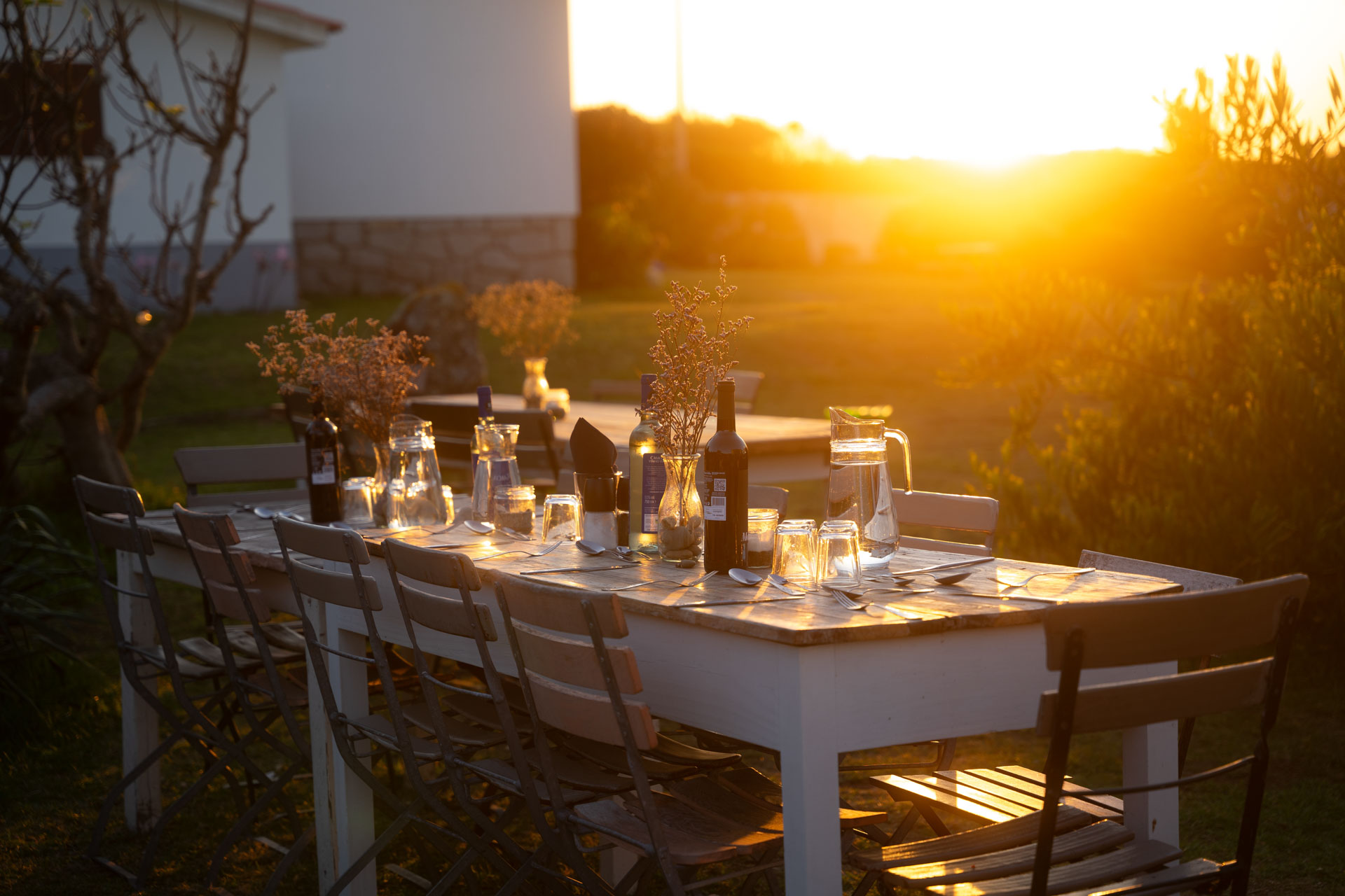 Goodtimes Sportreisen Surfcamp Portugal eingedeckter Tisch im Garten bei Sonnenuntergang