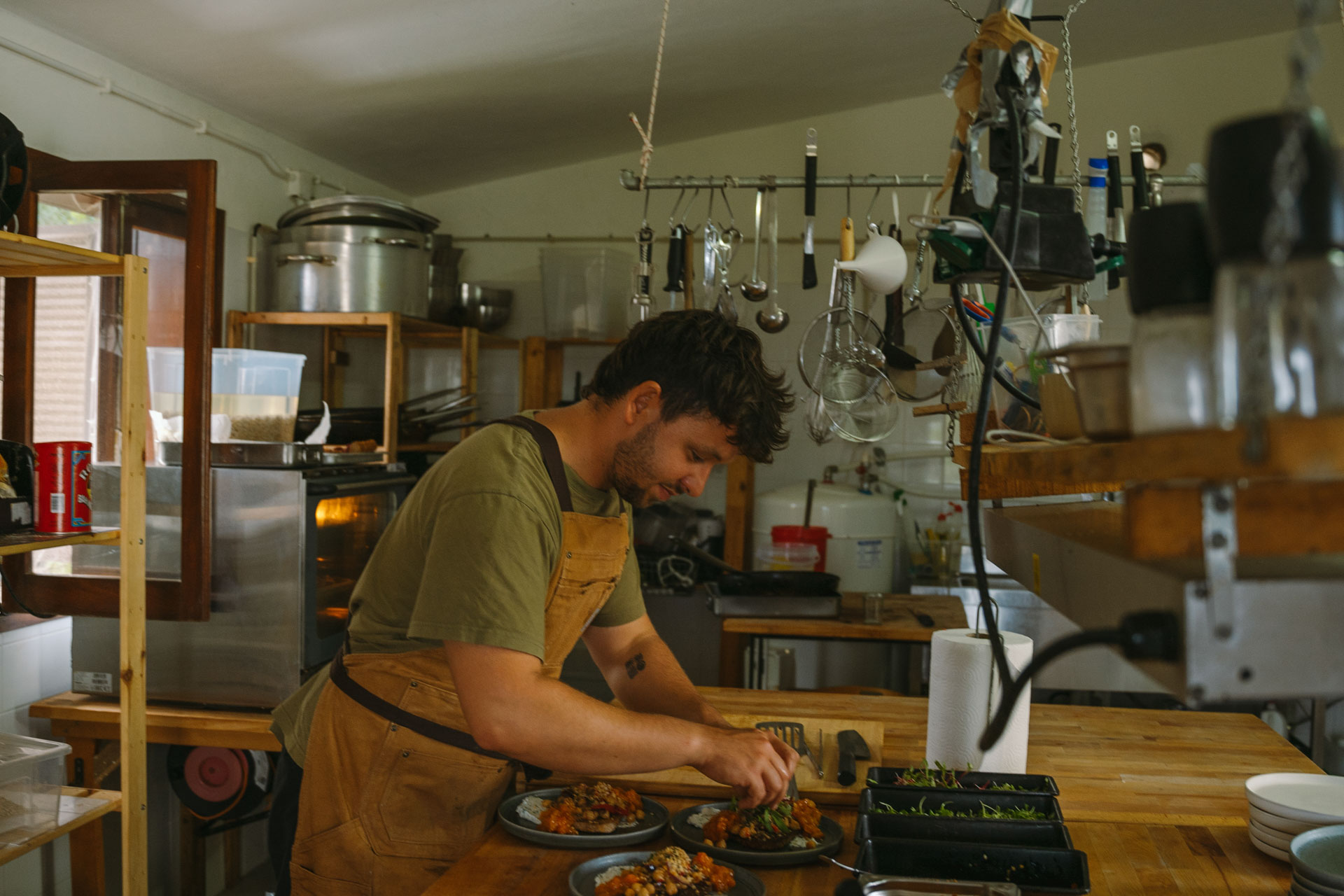 Goodtimes Sportreisen Surfcamp Portugal Koch richtet Teller in der Küche an