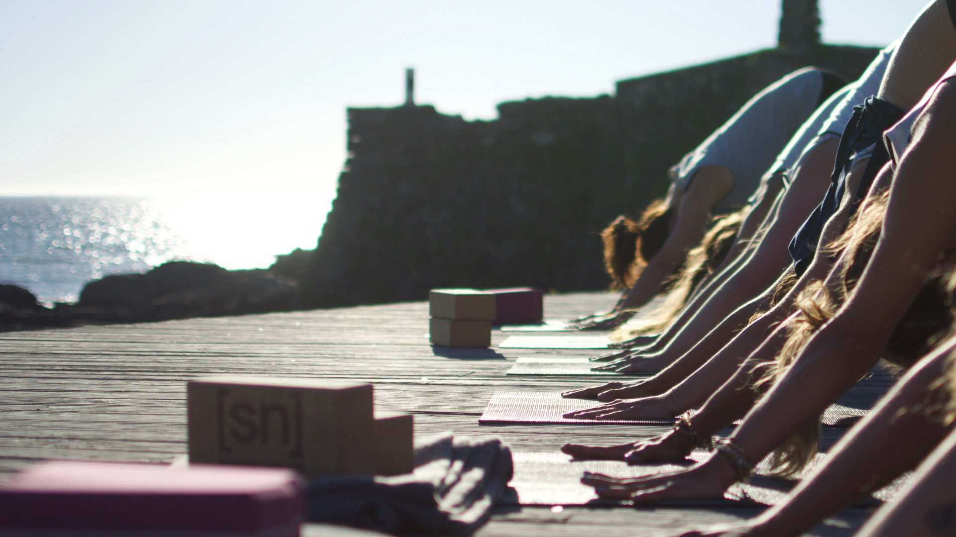 Goodtimes Sportreisen Surfcamp Portugal Yogagruppe auf Plattform am Meer