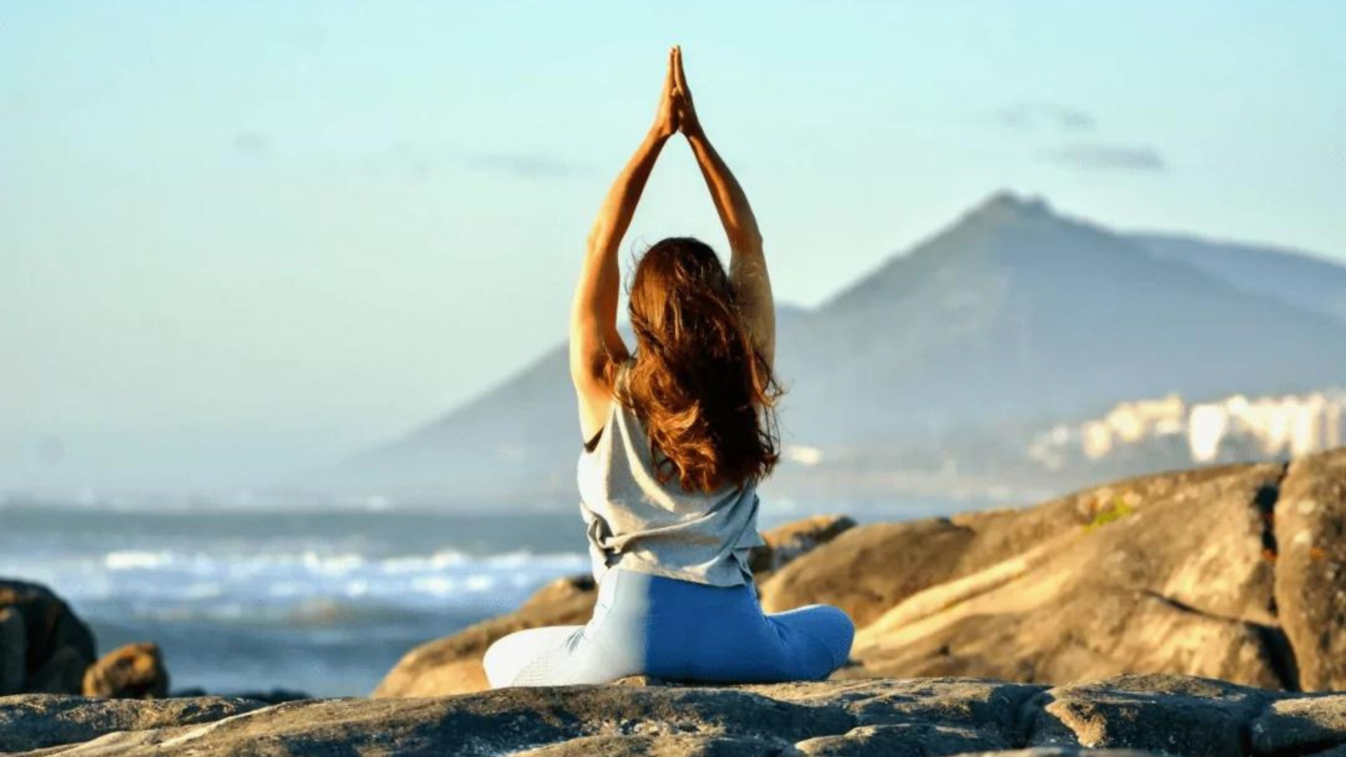 Goodtimes Sportreisen Surfcamp Portugal Yogalehrerin auf Felsen am Meer