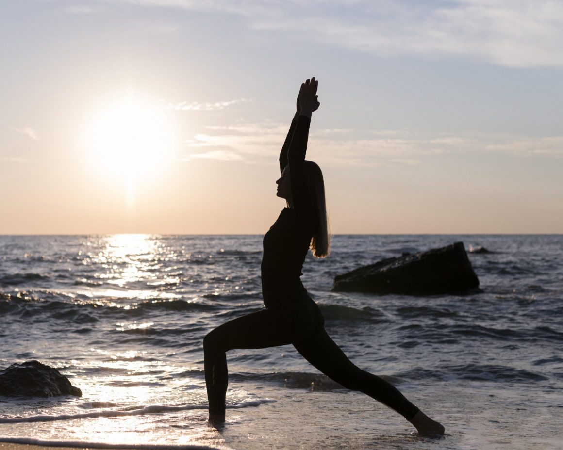 Yoga Ausfallschritt am Meer bei tief stehender Sonne